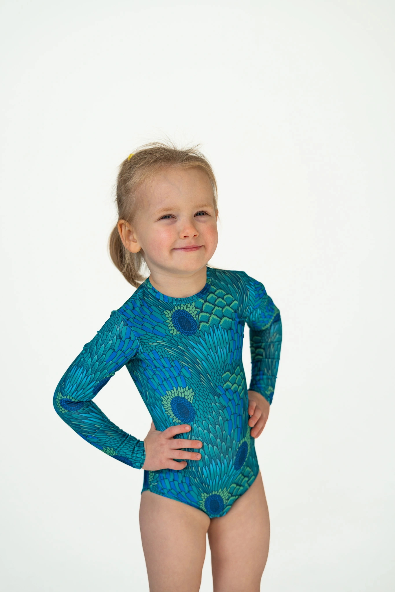 Z20 Peacock Children's long-sleeve tan-through one-piece swimsuit in teal peacock feather print, front view