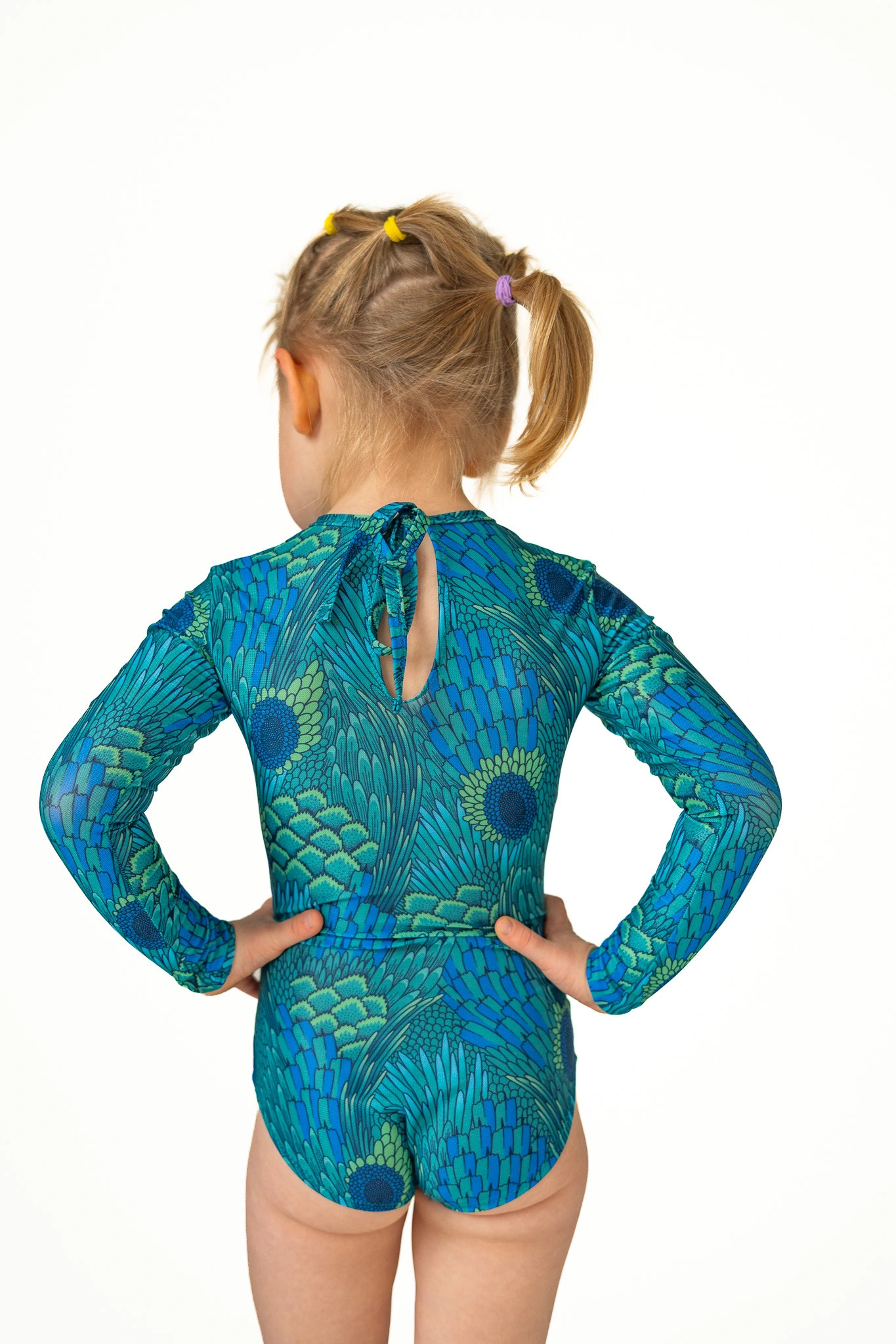 Z20 Peacock Children's long-sleeve tan-through one-piece swimsuit in teal peacock feather print, back view with keyhole tie