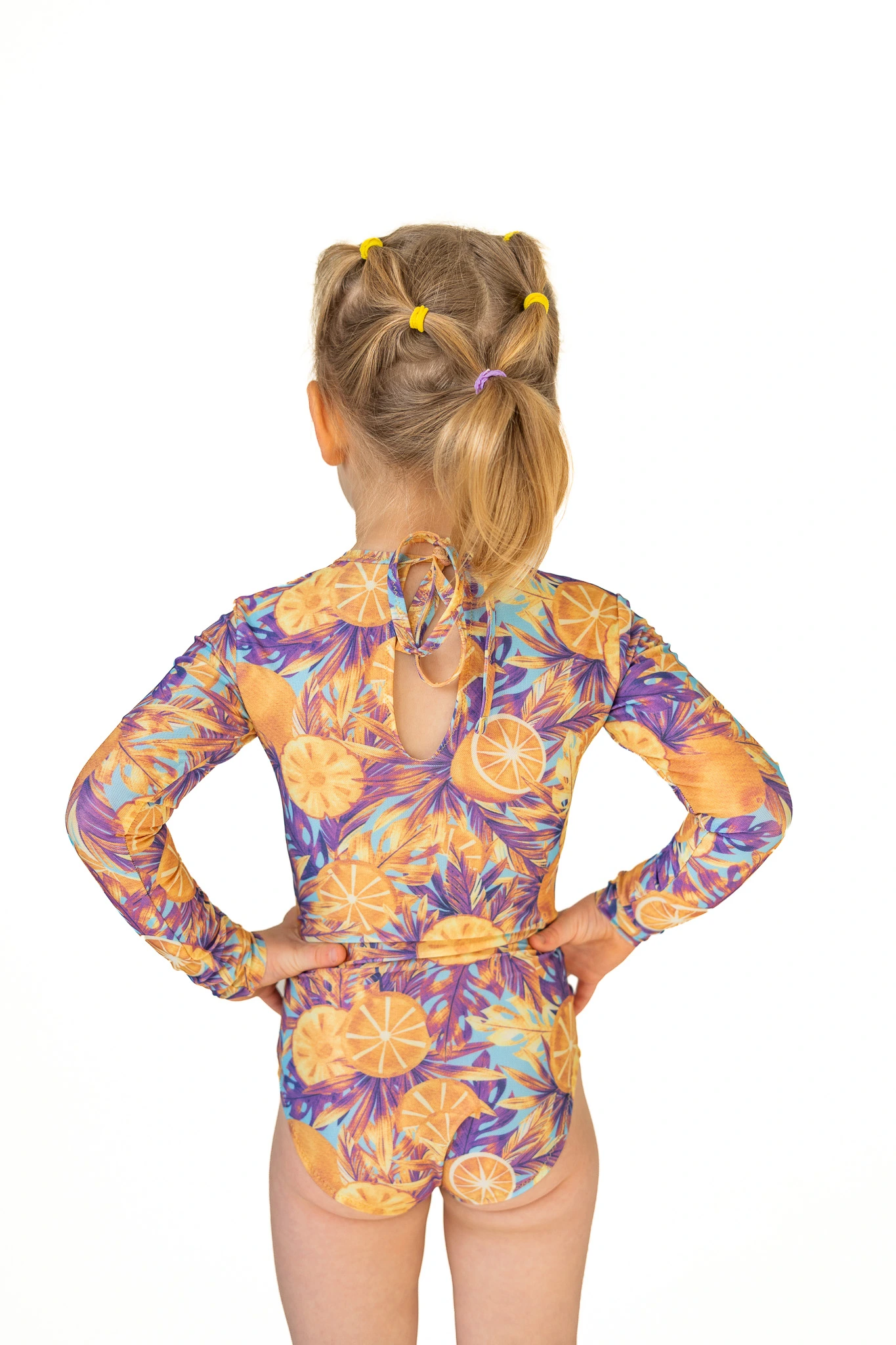 Z20 Lemon paradise Children's long-sleeve tan-through one-piece swimsuit in orange and purple floral print, back view with keyhole tie