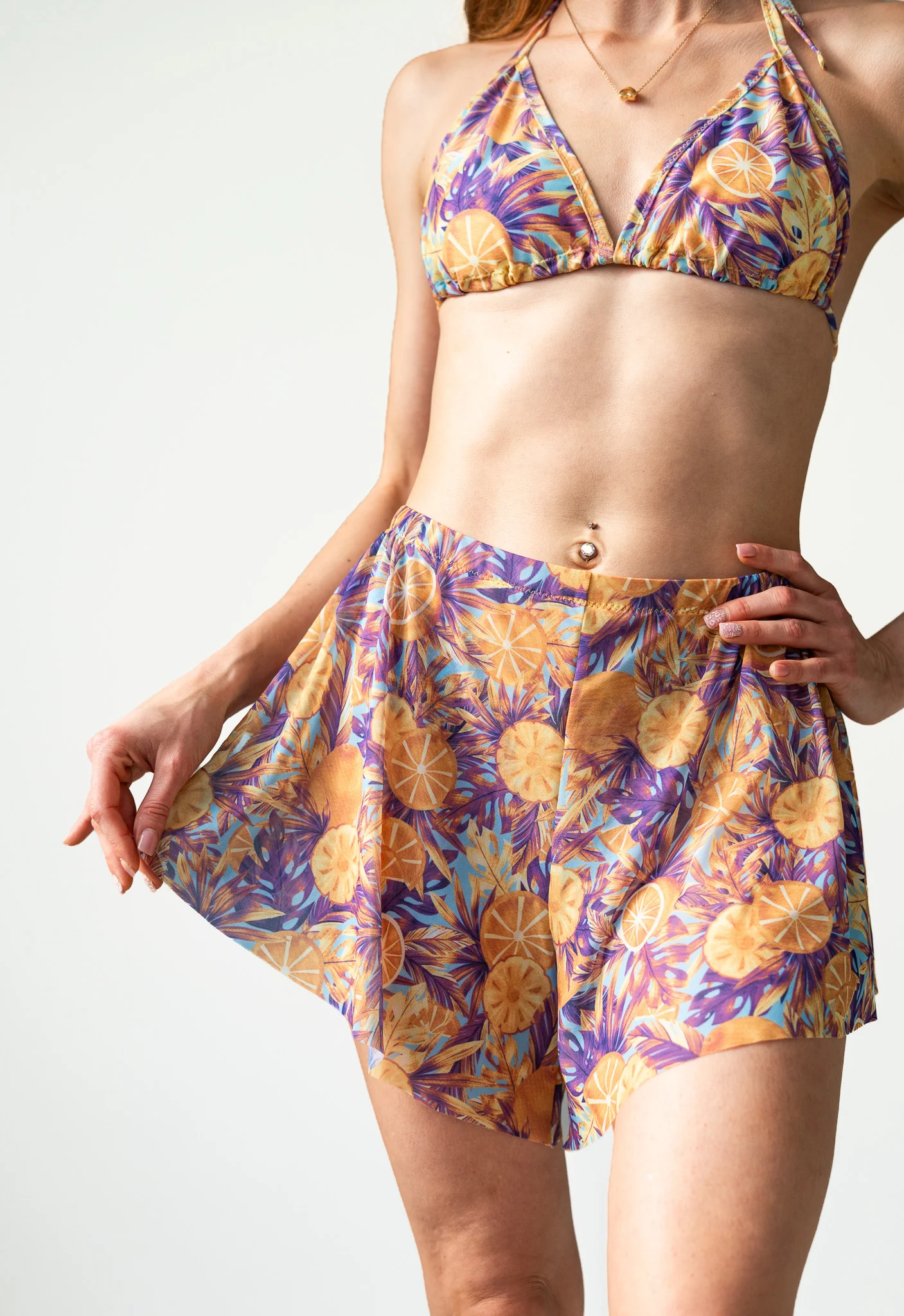 Close-up of purple and yellow floral flowy shorts and matching bikini top Close-up of purple and yellow floral flowy shorts and matching bikini top