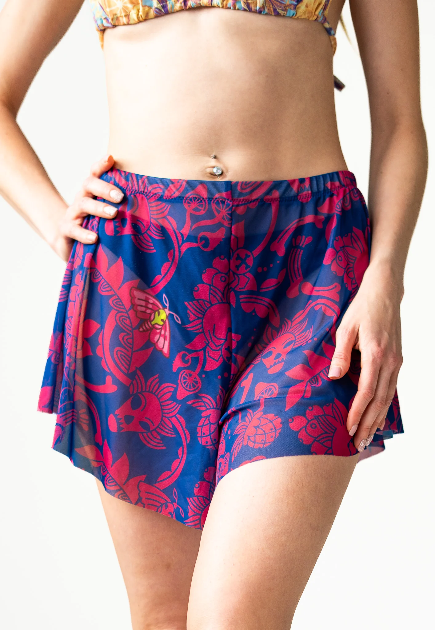 Front view of blue and magenta floral print shorts with hands on hips Front view of blue and magenta floral print shorts with hands on hips
